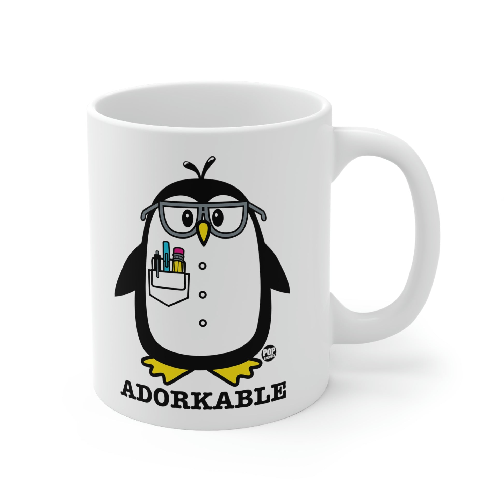 white mug with black penguin with a coat and pens in pocket and glasses